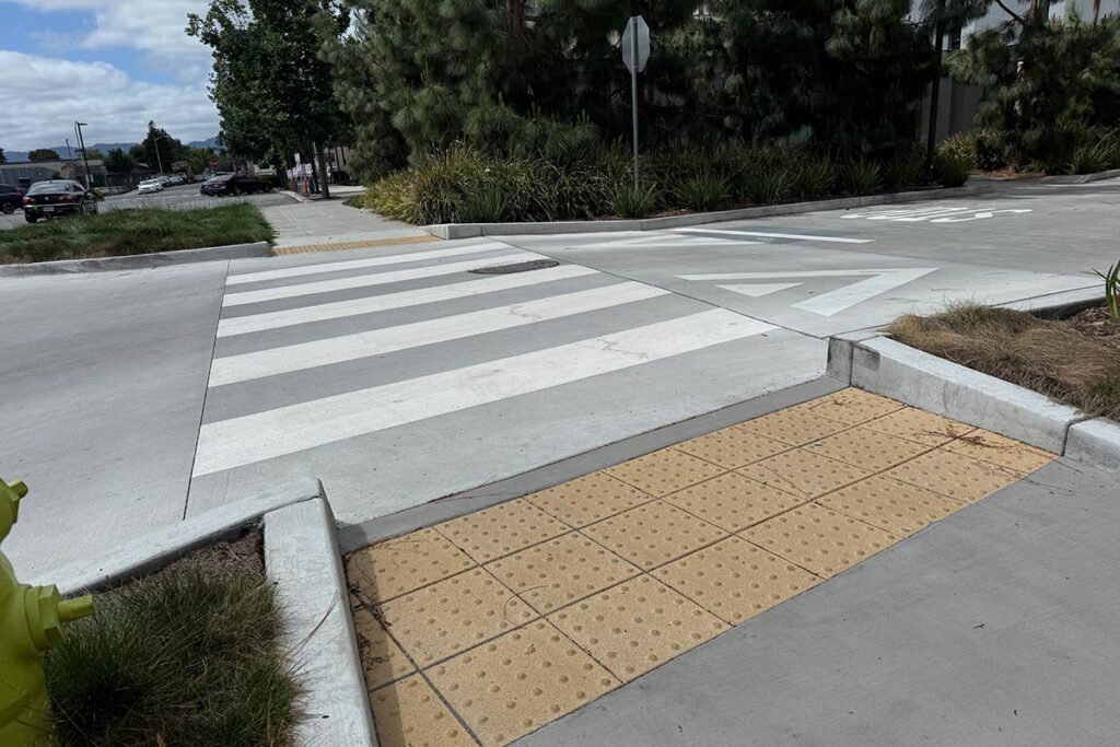 The raised driveway entrance at the Barron Garage, featuring a new crosswalk and tactile paving designed to prevent campus flooding.